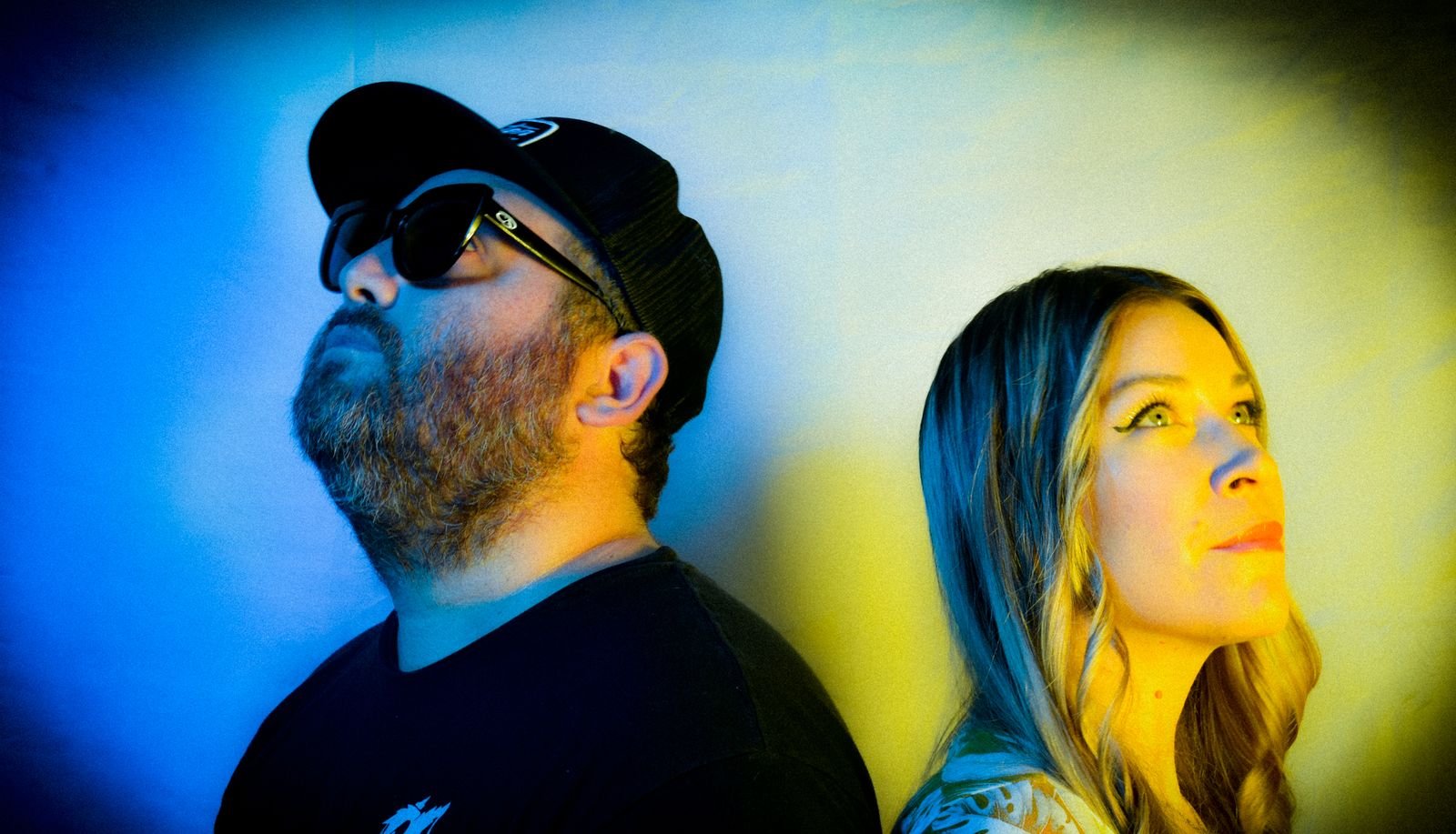 Hans and Jeanna in sunglasses under yellow and blue light